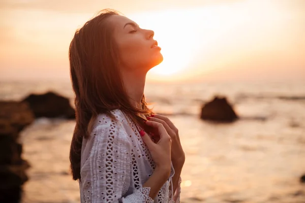 Seitenansicht der hübschen brünetten Frau im leichten Sommerkleid — Stockfoto