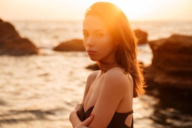 Bikini poz içinde genç esmer kadın yan görünüm