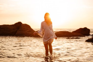 Denizde yürüyen ışık yaz içinde neşeli esmer kadın