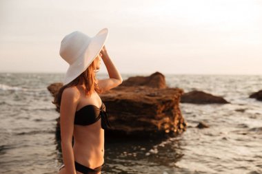 Şapka ve bikini esmer kadın yan görünüm