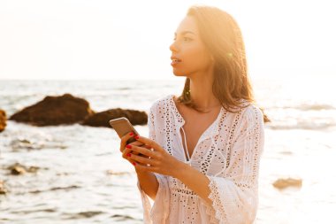 Plajda durup hafif yaz içinde genç kadın