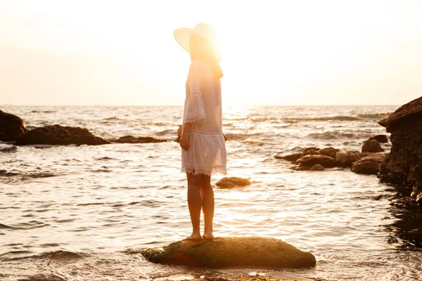 Back view of woman in light summer dress and hat — Stock Photo, Image