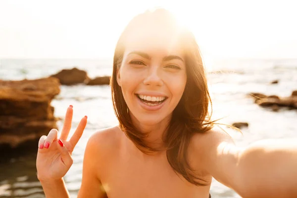 Imagen de cerca de la mujer alegre haciendo selfie y mostrando paz —  Fotos de Stock