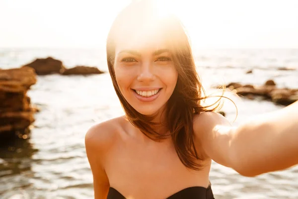 Close up image of pleased woman making selfie on beach — Stock Photo, Image