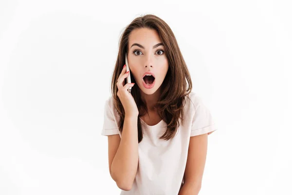 Chockad brunett kvinna prata genom smartphone — Stockfoto