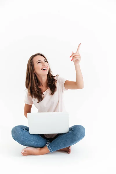 Lodret billede af glad brunette kvinde holder bærbar computer - Stock-foto