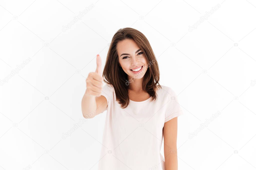 Pleased woman showing thumb up and looking at the camera