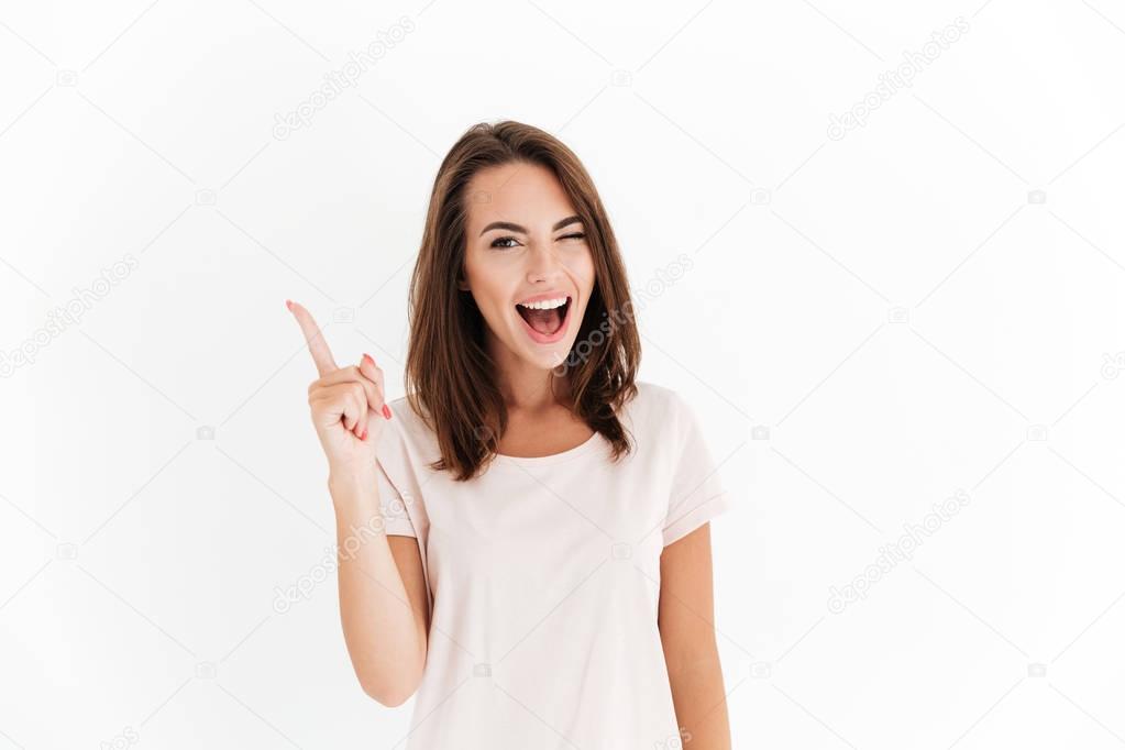 Happy brunette woman having idea and winks at the camera