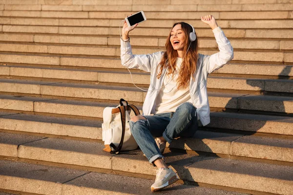 Agréable femme brune en vêtements d'automne assis sur les escaliers — Photo