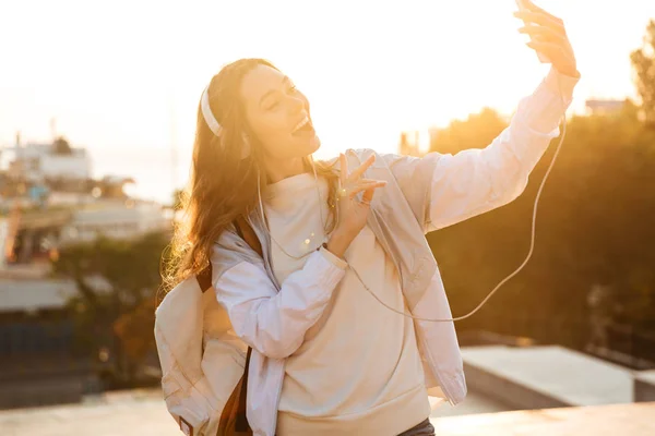 Vrolijke brunette vrouw in herfst kleren maken selfie op haar — Stockfoto