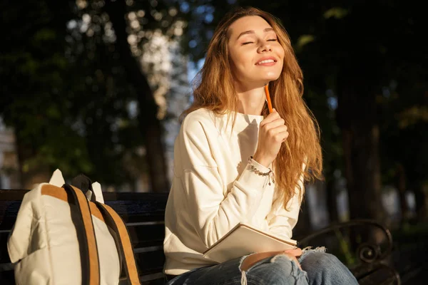 Sorrindo mulher pensativa em roupas de outono com olhos fechados — Fotografia de Stock