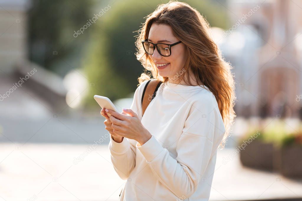 Smiling brunette woman in eyeglasses and autumn clothes