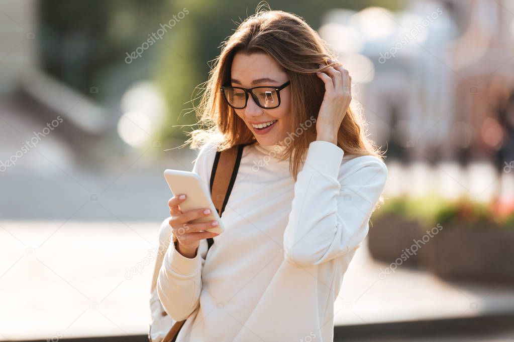 Surprised happy brunette woman in eyeglasses and autumn clothes