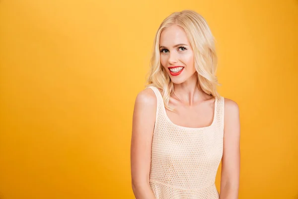 Schöne junge blonde Frau steht isoliert über gelb — Stockfoto