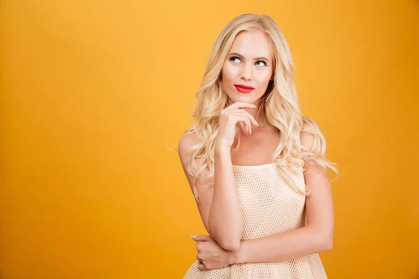 Ziemlich nachdenkliche junge blonde Frau steht isoliert — Stockfoto