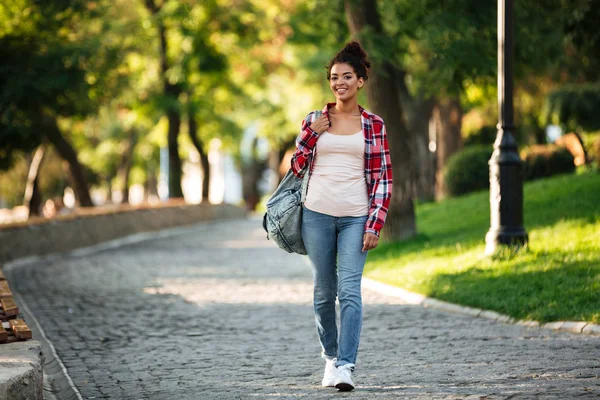 Lachende jonge Afrikaanse vrouw lopen buiten — Stockfoto