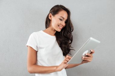Tablet bilgisayar kullanan gülümseyen Asyalı kadın
