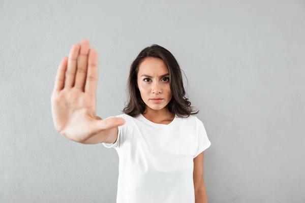 Ernsthafte junge asiatische Frau zeigt Stop-Geste mit ihrer Handfläche — Stockfoto