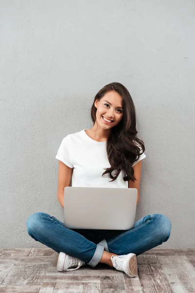 Dizüstü bilgisayar üzerinde çalışan mutlu genç Asyalı kadın — Stok fotoğraf