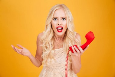 Telefon tutan karışık genç sarışın kadın.