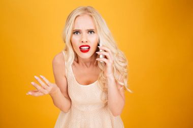 Karışık kızgın genç sarışın kadın telefonla konuşuyor.