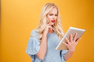 Tablet bilgisayar kullanan karışık genç sarışın kadın.
