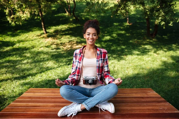 Жінка-фотограф сидить на відкритому повітрі в парку медитувати — стокове фото