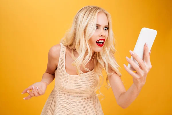 Confundido sorprendido joven rubia utilizando el teléfono móvil . — Foto de Stock