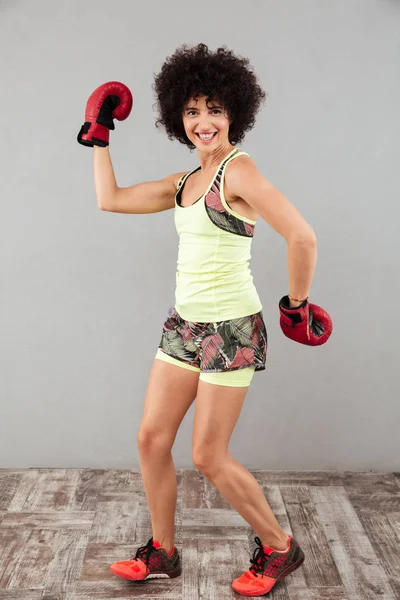 Imagen completa de la mujer deportiva feliz posando con guantes de boxeo — Foto de Stock