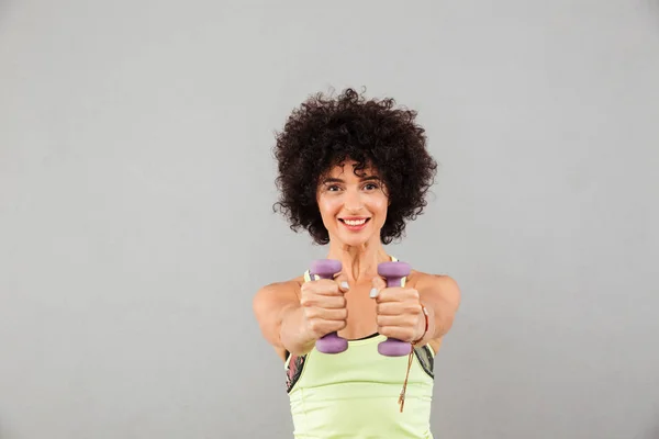 Sorrindo mulher fitness fazendo exercício com halteres — Fotografia de Stock