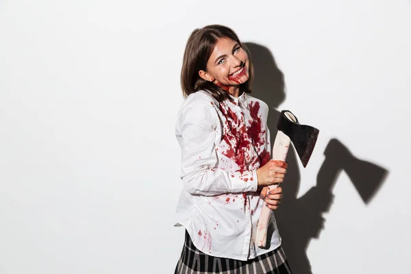 Bir balta tutan deli gülümseyen zombi kadın — Stok fotoğraf