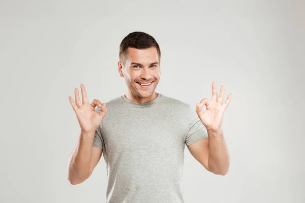 Un giovanotto felice che mostra un gesto positivo. Guardando la macchina fotografica . — Foto Stock