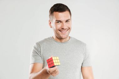 Mutlu adam Rubik küpü holding.