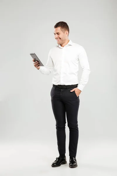 Usměvavý mladý muž u tabletový počítač. — Stock fotografie