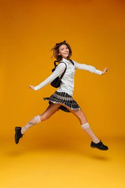 Gülümseyen bir neşeli kız öğrenci üniformalı tam uzunlukta portresi