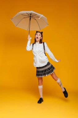 Tek tip holding şemsiye bir komik genç kız öğrenci portresi