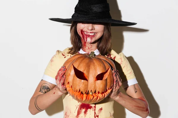 Mujer sonriente en traje de halloween sosteniendo calabaza curvada —  Fotos de Stock