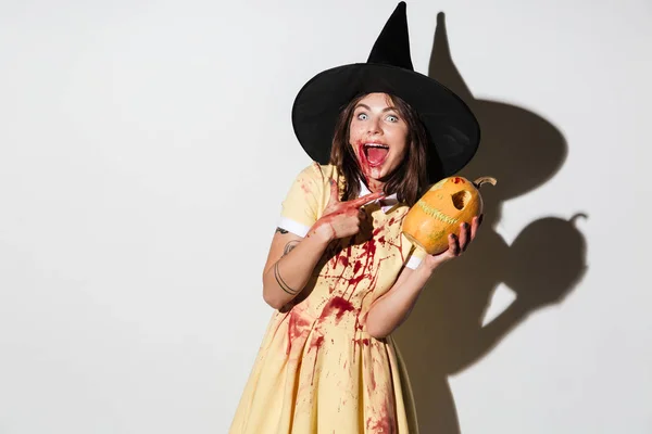 Mulher chocada em halloween traje segurando abóbora — Fotografia de Stock