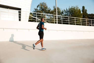 Kulaklık bir genç Afrikalı sporcu tam uzunlukta portresi