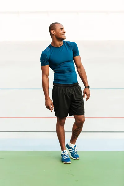 Full length portrait of a smiling muscular sportsman — Stock Photo, Image