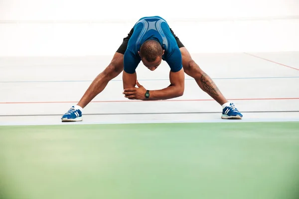 Ritratto completo di un giovane sportivo che fa stretching — Foto Stock