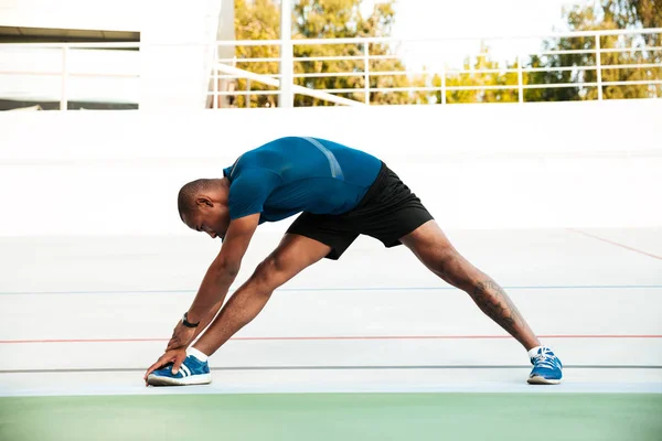 Retrato de comprimento total de um desportista motivado fazendo alongamento — Fotografia de Stock