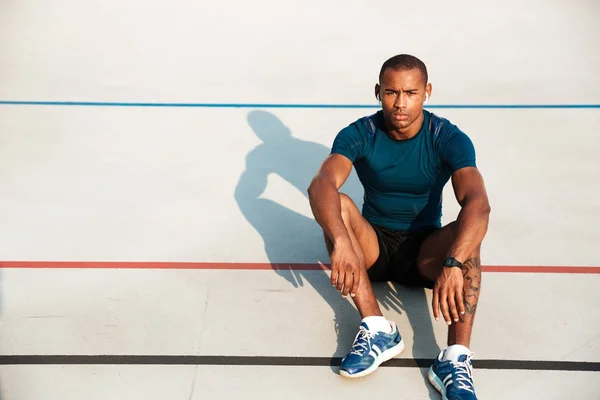 Ritratto di un serio atleta africano in cuffia a riposo — Foto Stock