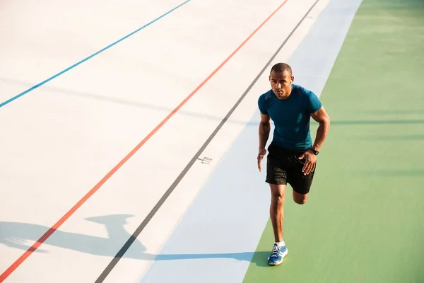 Po celé délce portrét svalnatý sportovec běží — Stock fotografie
