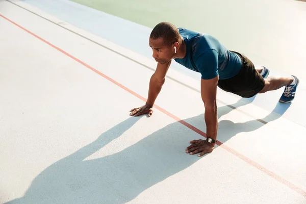 Retrato de un deportista afroamericano muscular en forma haciendo tablón — Foto de Stock