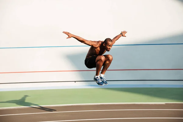 Portrét nahé půlky silné vejde africké sportovce skákání — Stock fotografie