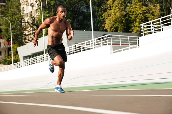 Foto de un joven atleta afro-americano corriendo en pista ou — Foto de Stock