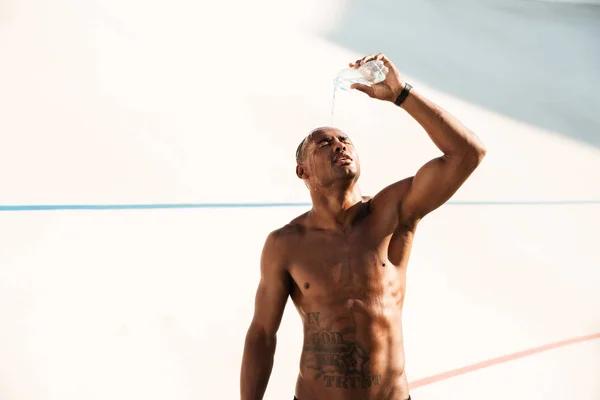 Foto de un joven deportista africano derramando agua sobre su cabeza — Foto de Stock