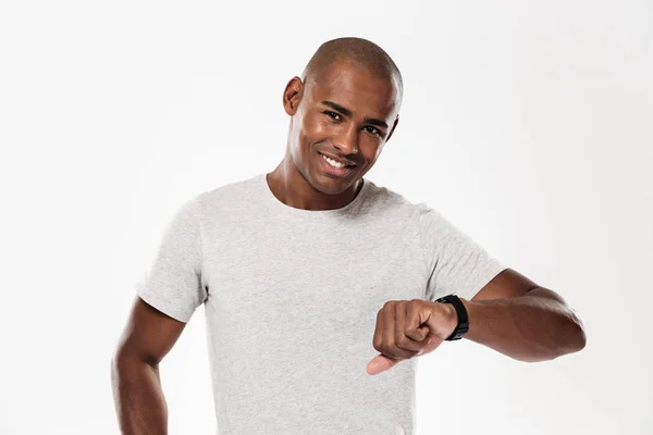 Cheerful young african man using watch. — Stock Photo, Image