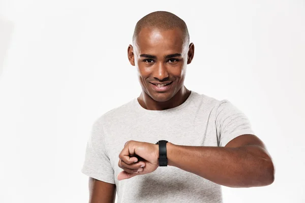 Cheerful young african man using watch. — Stock Photo, Image